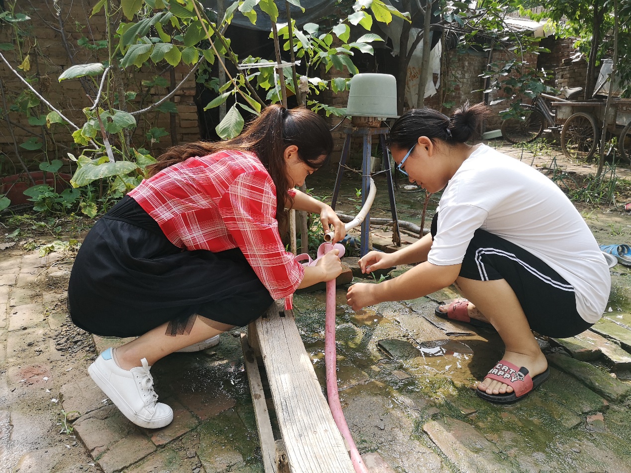 (支教队员吴莲帮助苗晓雨修水管 李佳楠摄)